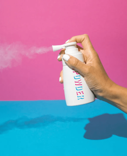 Hand spraying bottle of the refresh powder.