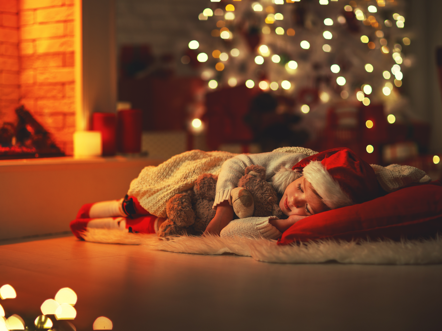 happy child girl fell asleep near tree on Christmas Eve