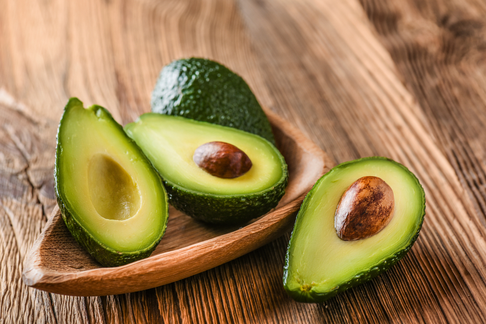 Avocados on a wooden table. 