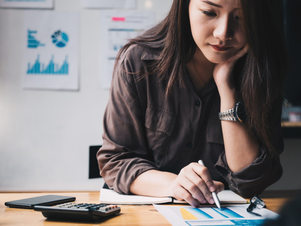 Business woman using calculator for do math finance on wooden desk in office and business working background, tax, accounting, statistics and analytic research concept