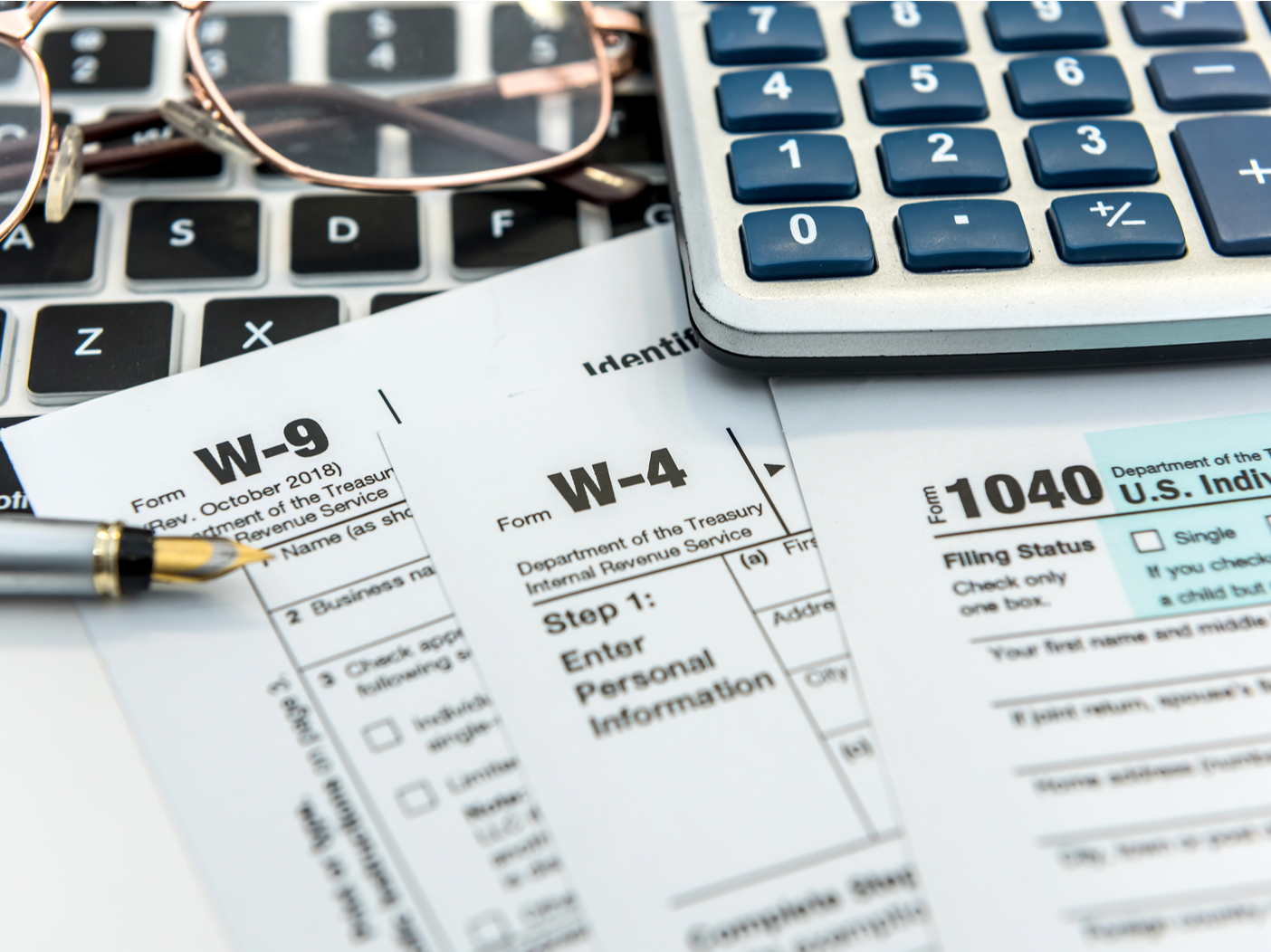 Financial time tax form with laptop and calculator. Office paperwork. Accounting