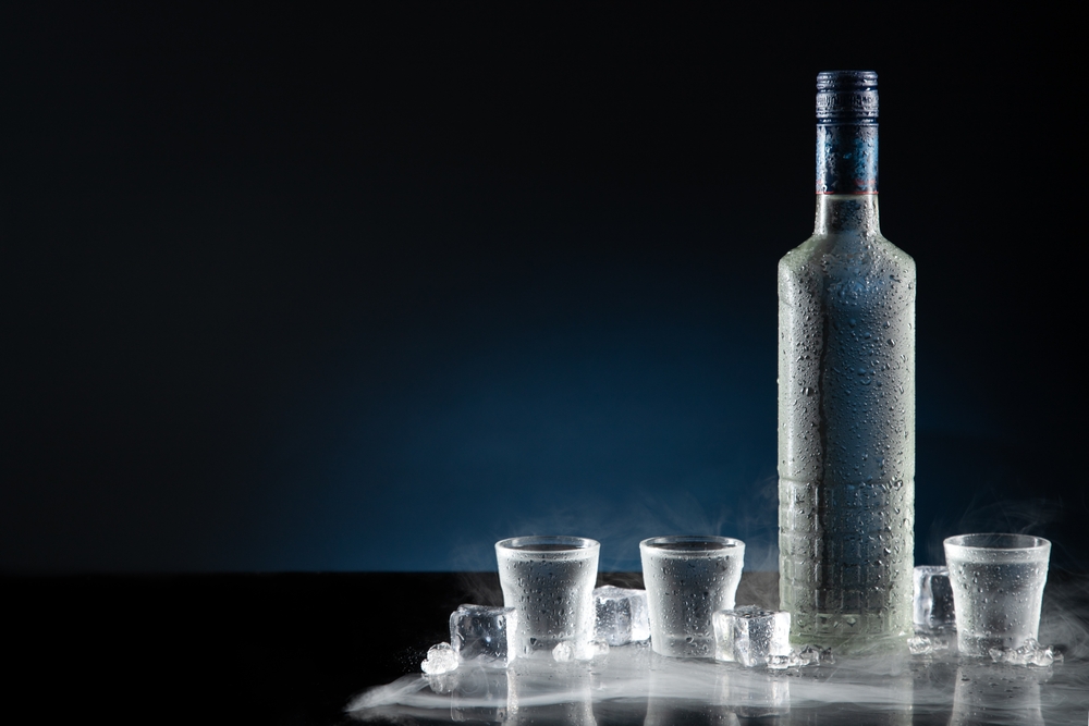 Ice-cold bottle of vodka with shot glasses