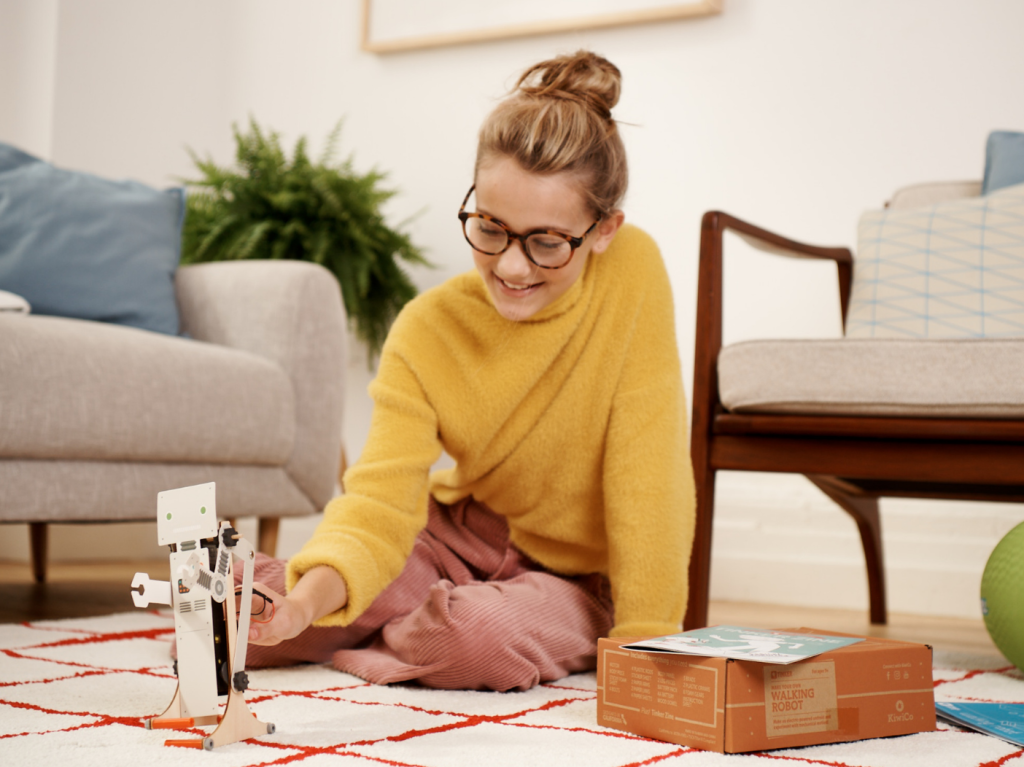 Girl plays with toy robot from KiwiCo tinker box