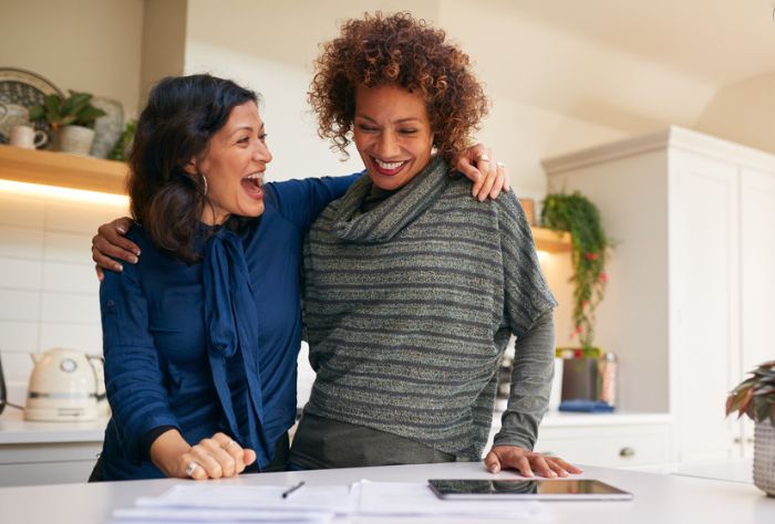 Couple smiling looking at financial paperwork on counter