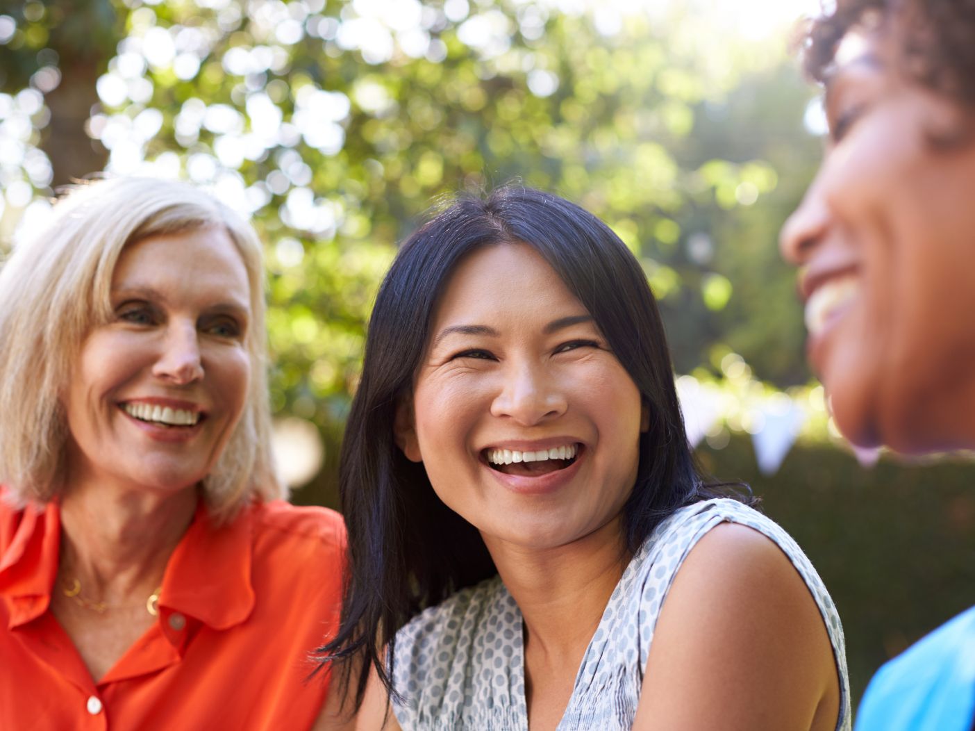 Three older women smiling and laughing