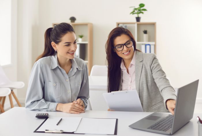 Two women look at finances together at table