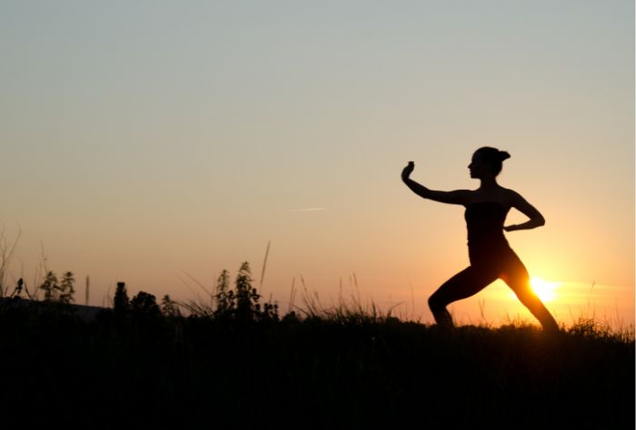 Silhouette of woman doing tai chi