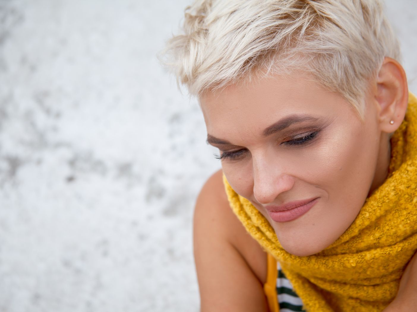 middle aged woman with short platinum hair and smokey eye makeup