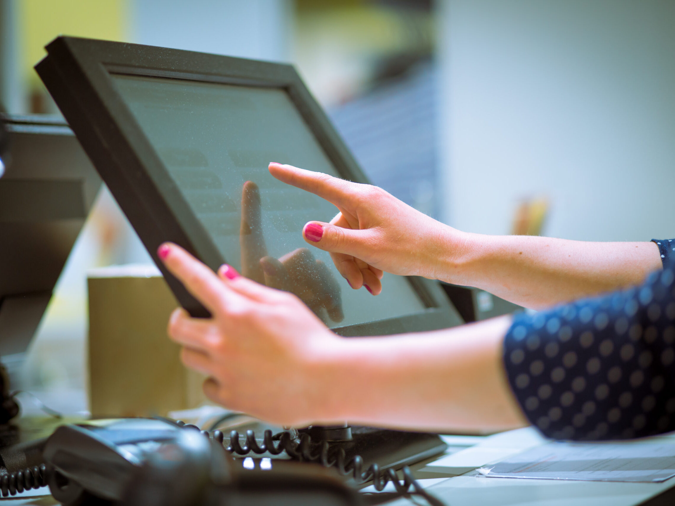 A woman's hand using a point-of-sale system.