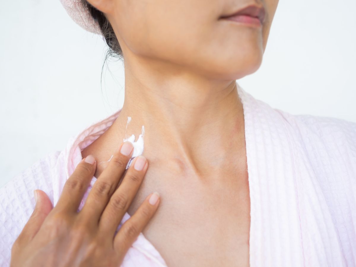 Middle-aged woman applying neck cream