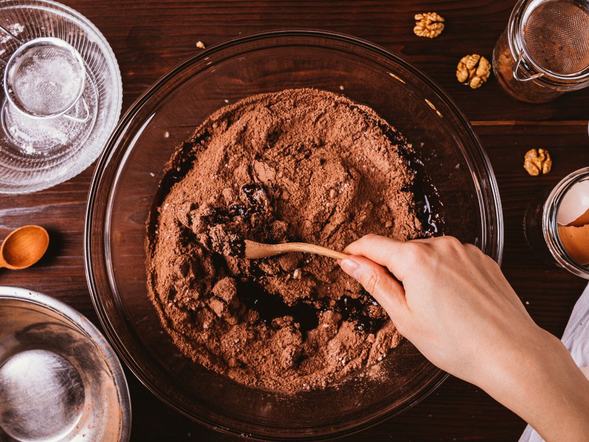 Person mixing cake mix with other ingredients in bowl