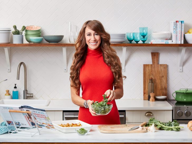 Melissa Urban preparing a dish using her Whole30 cookbook