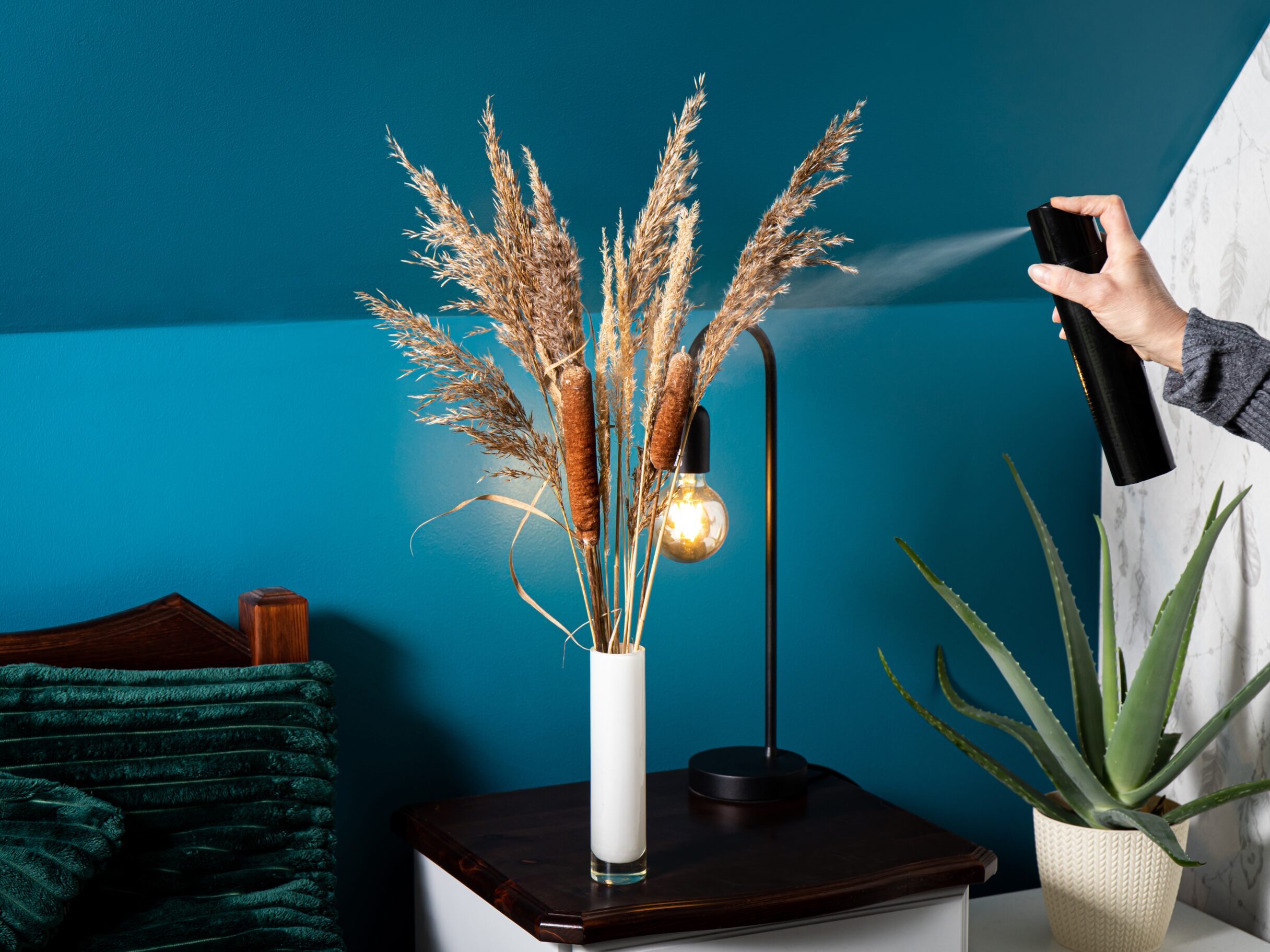 Hairspray being sprayed on a vase full of plants