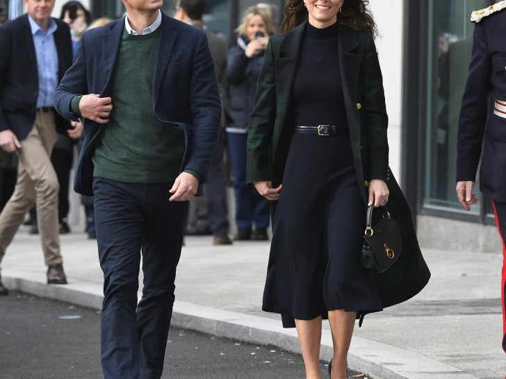 Prince William (L) in green sweater and navy blue pants walking outside together