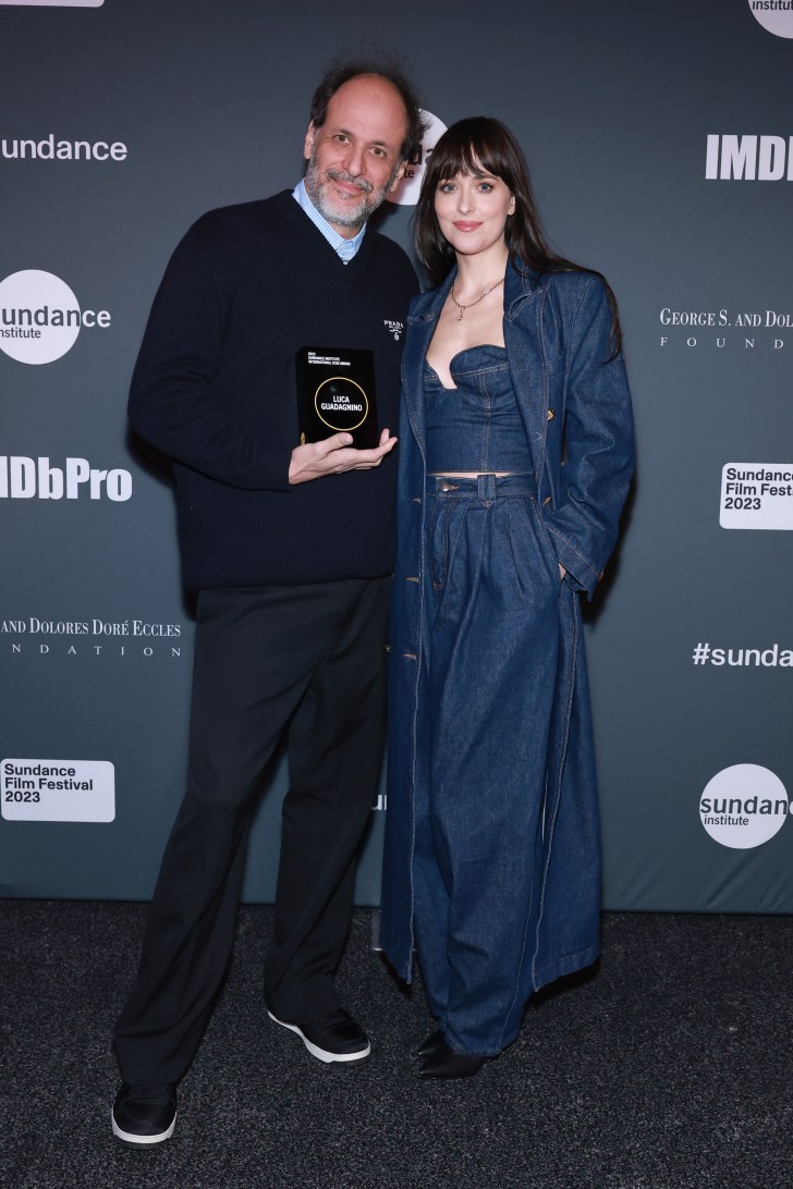 Luca Guadagnino (L) dressed in all-black and Dakota Johnson in all-denim outfit