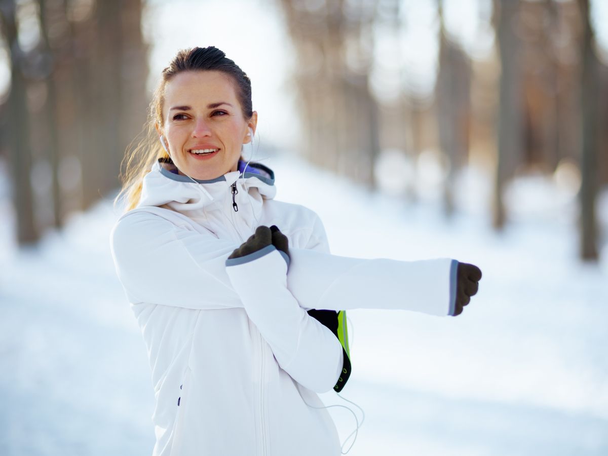 Woman stretching for a workout outside in the snow