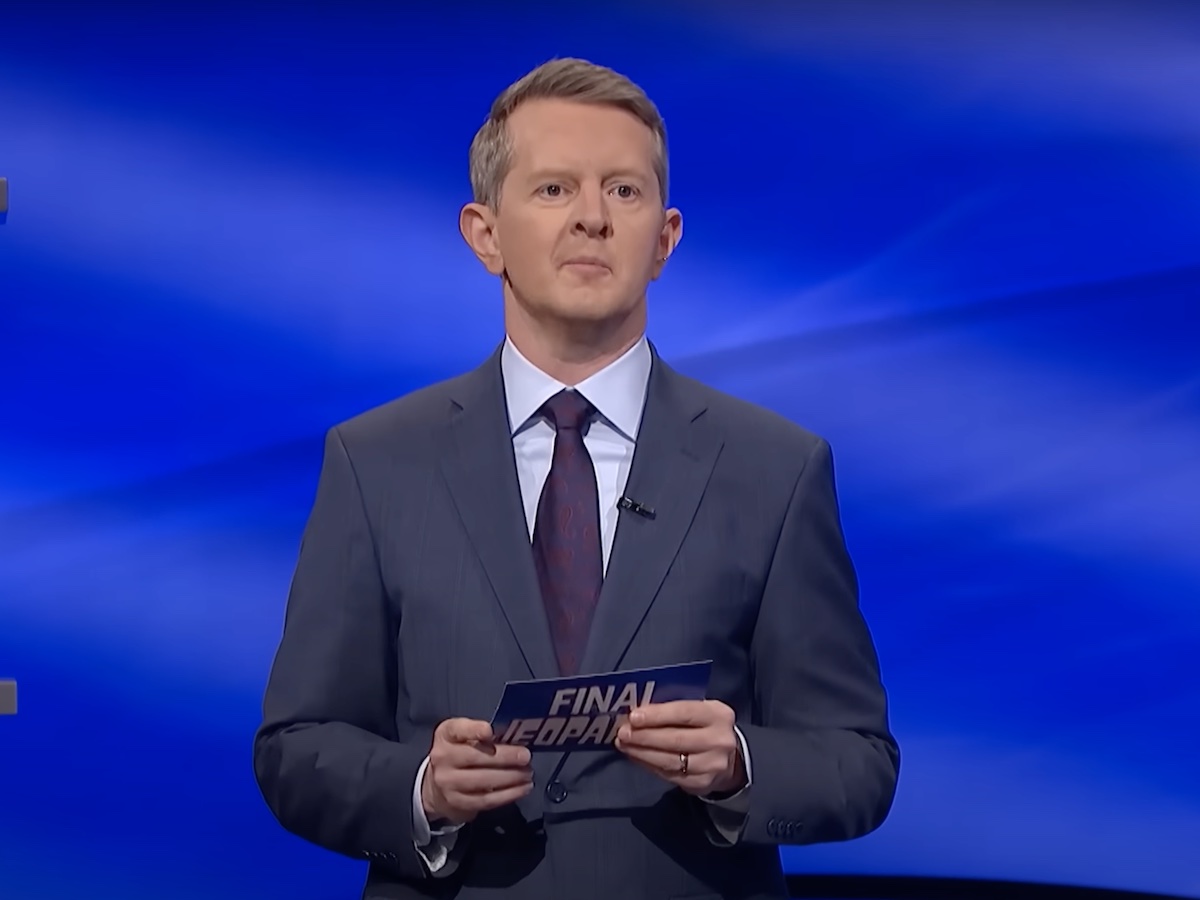 screenshot of Ken Jennings hosting Jeopardy! in a gray suit