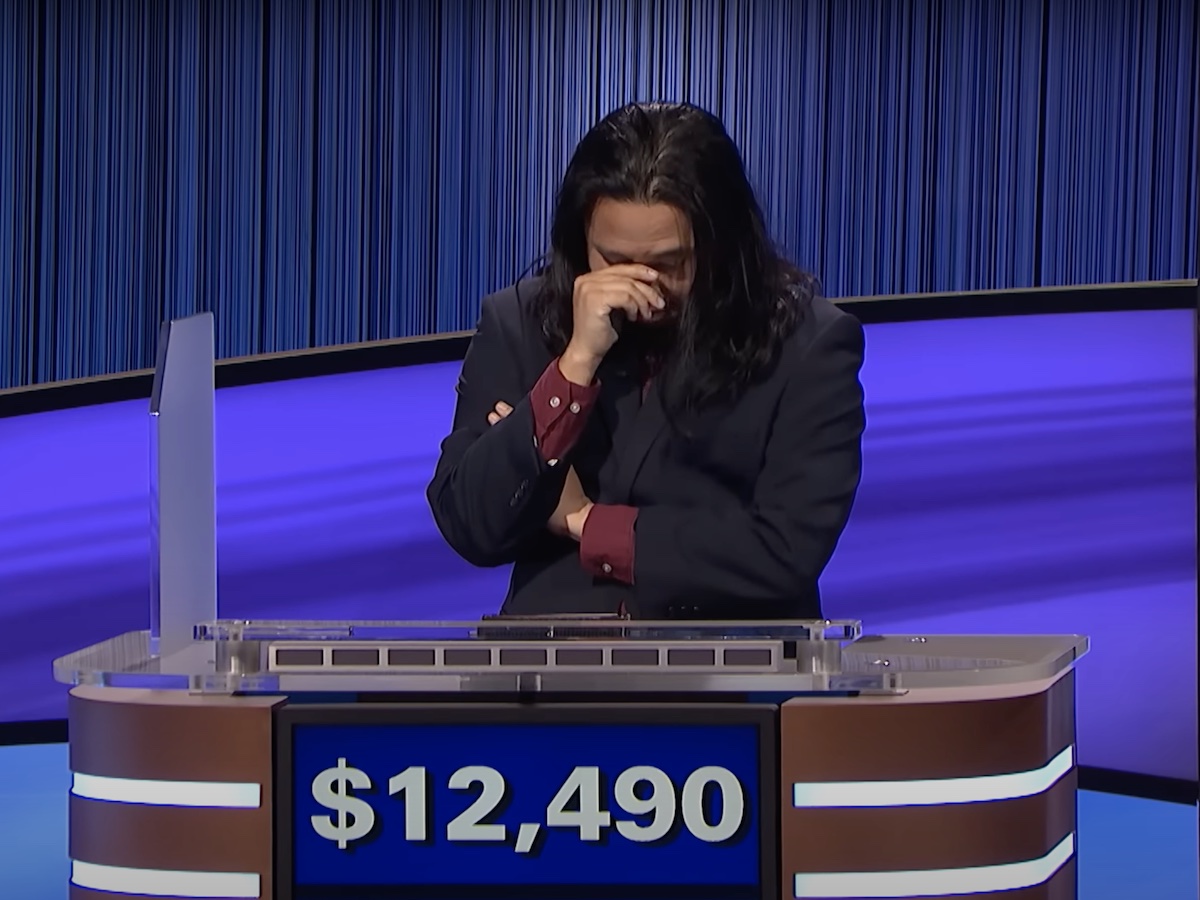 screenshot of Lloyd Sy during Final Jeopardy crossing his arms and covering his face with one hand