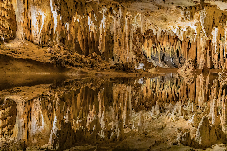 photo of the Luray Caverns depicting countless stalactites reflected in the mirror surface of a pool of water 