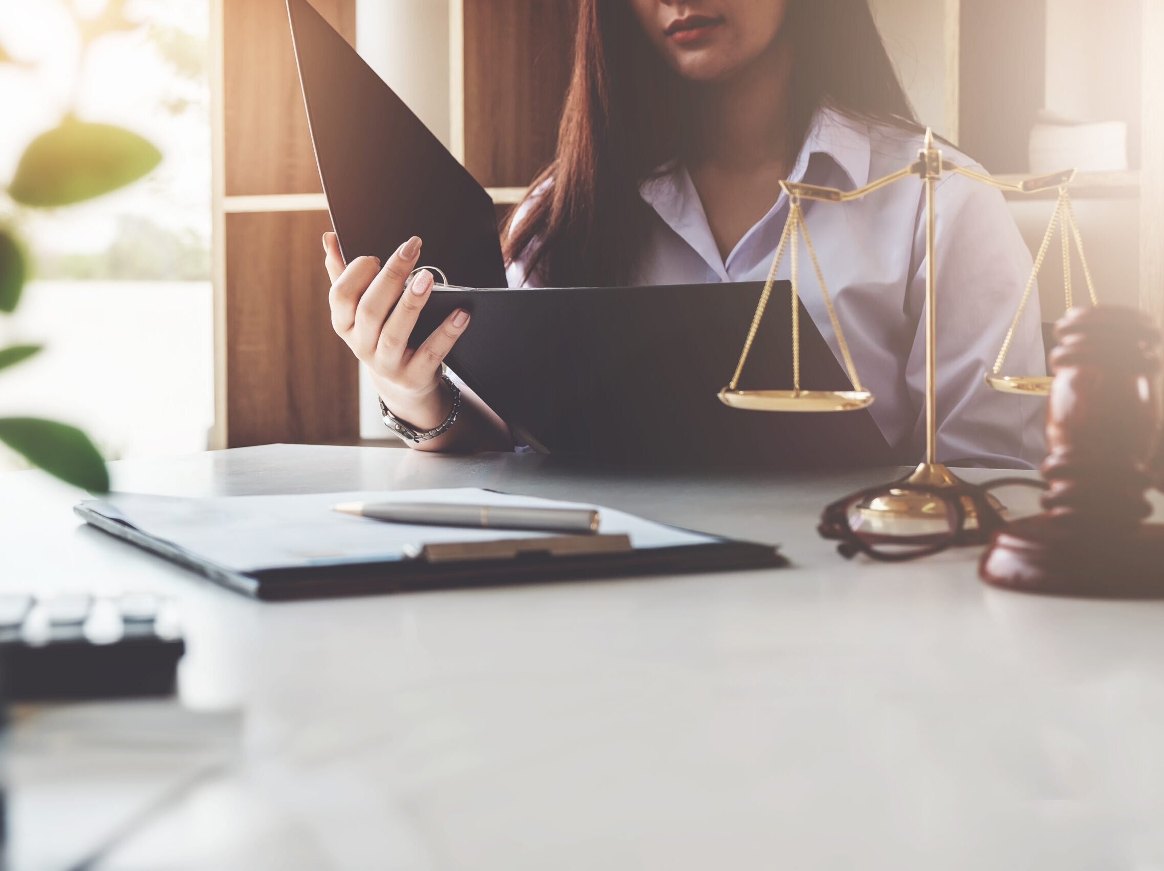 A woman reviewing paperwork in a legal office setting.