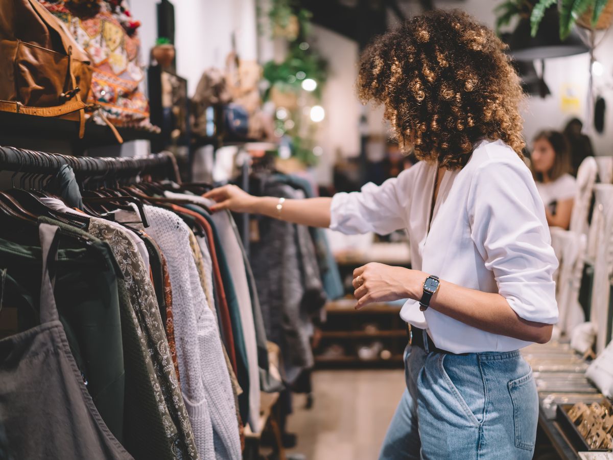 Woman searching through a rack of clothing while shopping