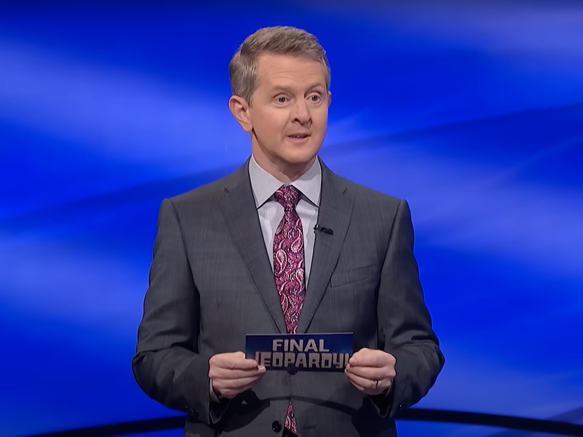 screenshot of Ken Jennings hosting Jeopardy! in a gray suit